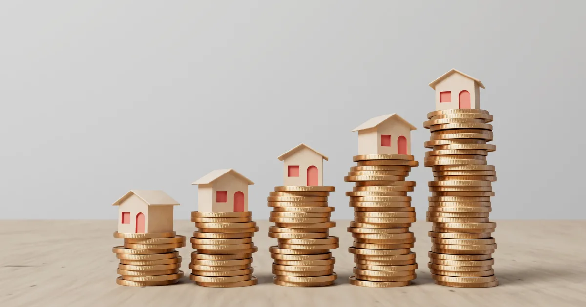 Rising stacks of coins with a small model house on top of each