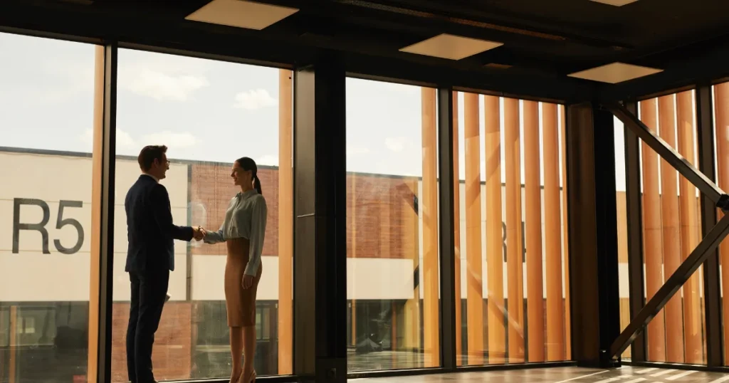 Two professionals shaking hands inside a modern building