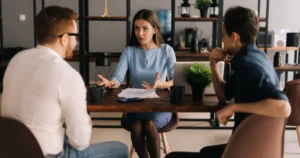 Three people in a business discussion at a table