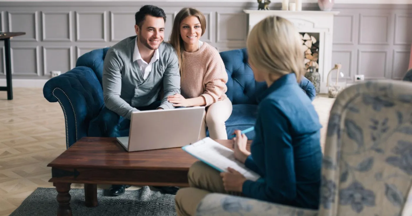 Couple and an adviser talking over a laptop in a living room