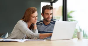Couple looking at a laptop together at a table